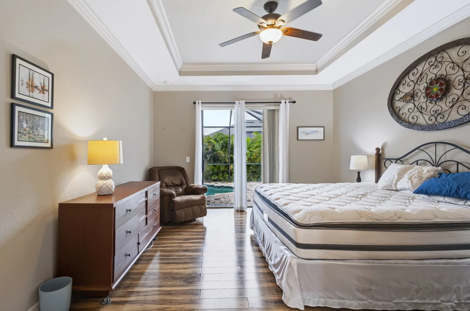 Bedroom with tray ceiling and poolside view