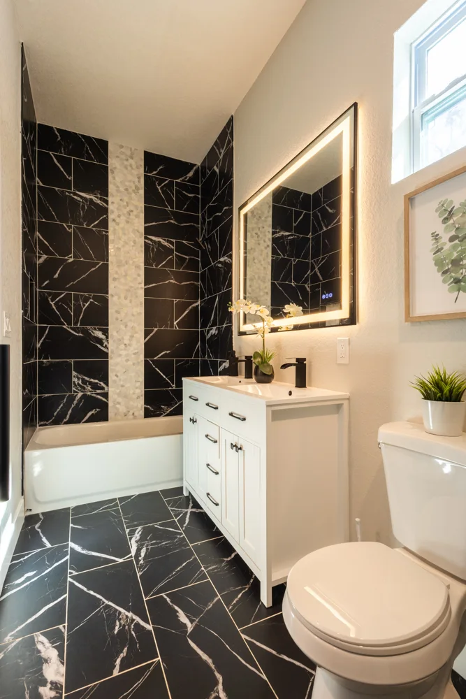 Bathroom vanity beside a black tile shower